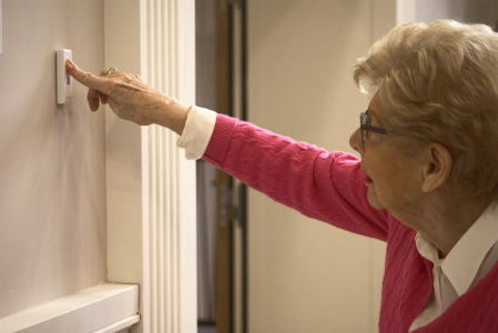 femme qui appuie sur le bouton d'appel au mur