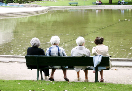 groupe de personnes âgées sur un banc face à un lac
