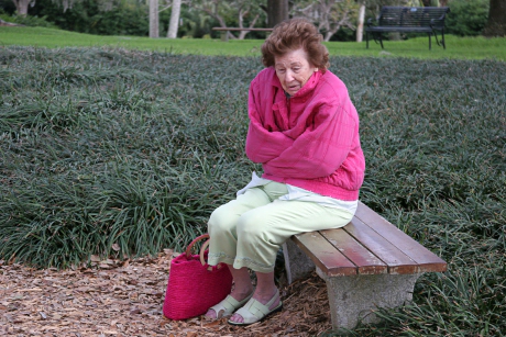 Femme âgée sur un banc femme a froid assise sur un banc