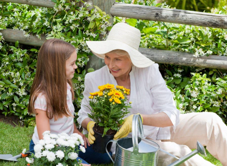 femme âgée jardine avec une petite fille