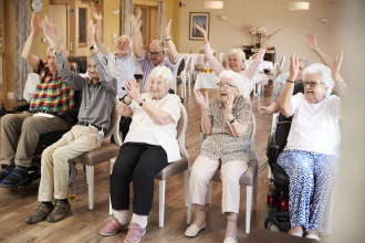 groupe de personnes âgées assis, heureux les bras levés